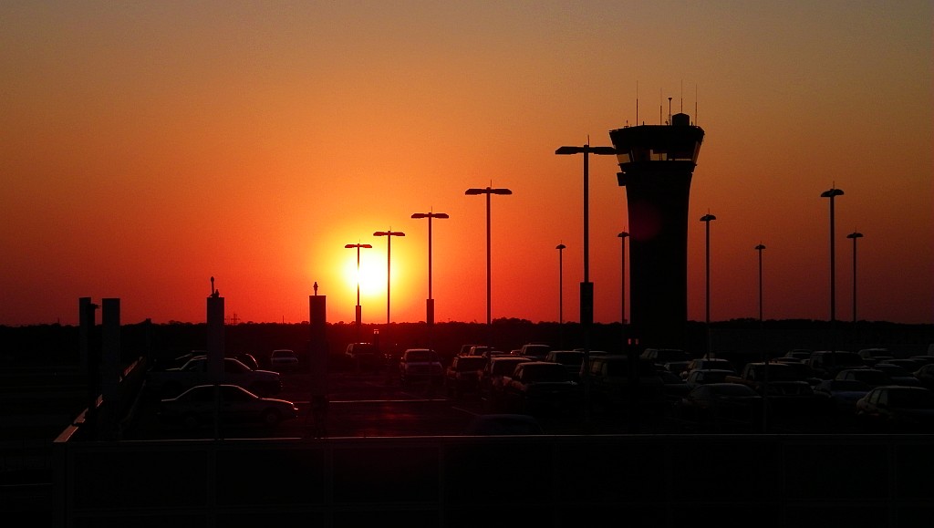 Image of a red sunset and outline of a airport control tower