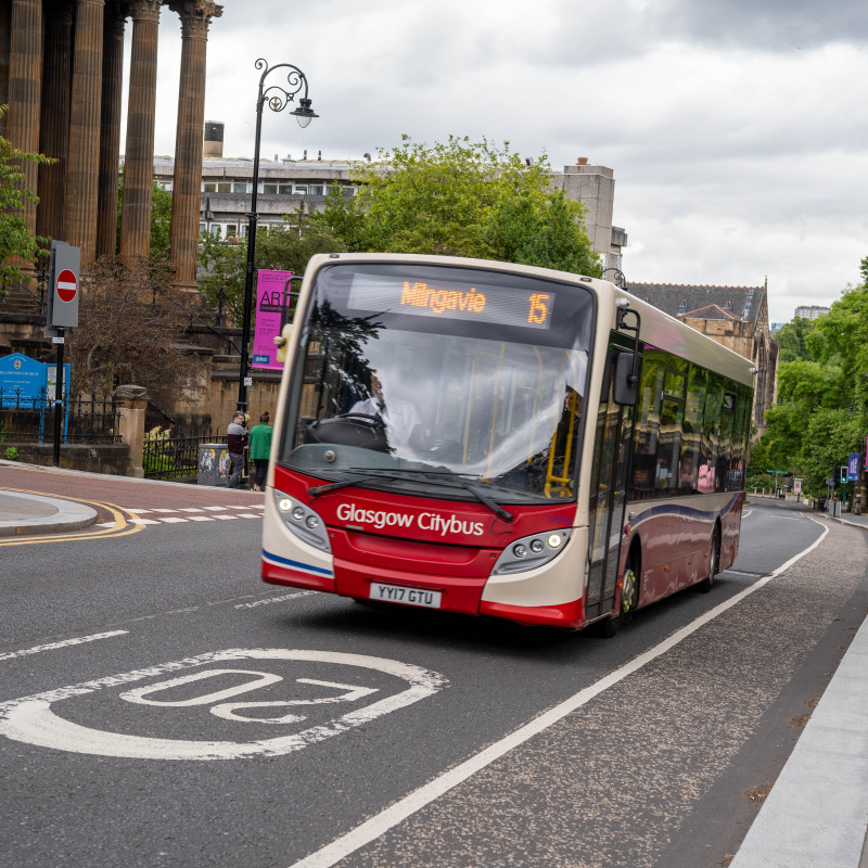 Red and white bus making a journey to Milngavie through Glasgow city centre