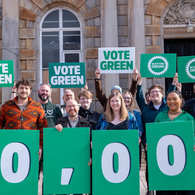 Scottish Greens candidates and members gathering at Langside Halls in Glasgow to celebrate record high membership numbers with 10k placard