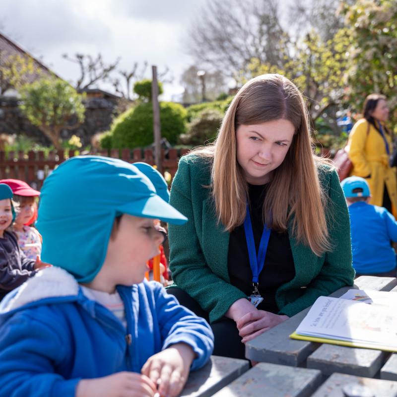 Gillian Mackay and Ross Greer on a visit to meet with nursery pupils and staff, sitting in the garden
