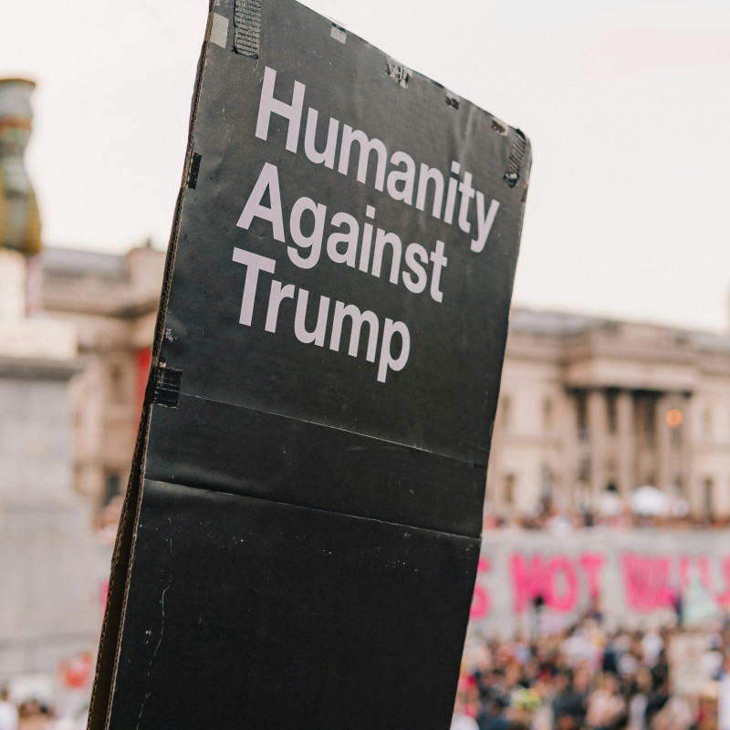 A sign reads Humanity Against Trump