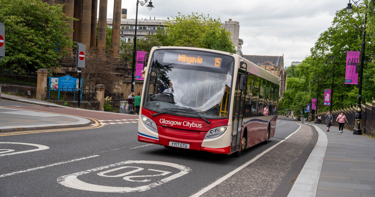 Red and white bus making a journey to Milngavie through Glasgow city centre
