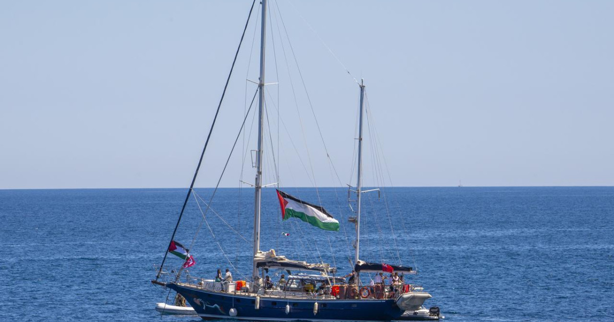 The Madleen sails through the ocean flying the Palestinian flag.