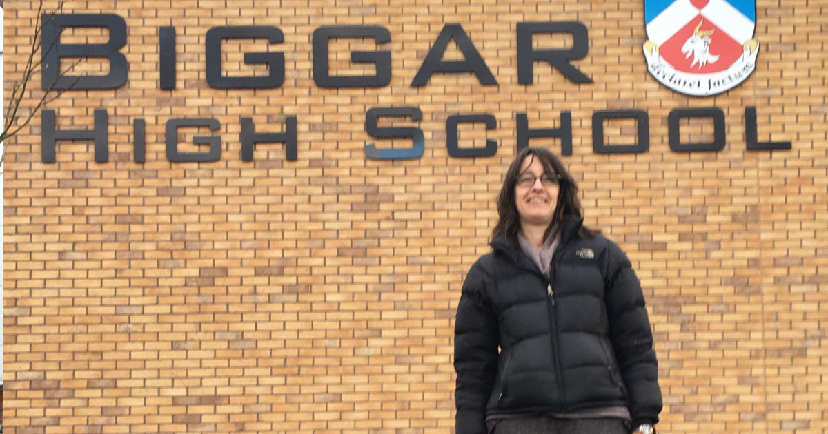 Janet Moxley in front of Biggar High School